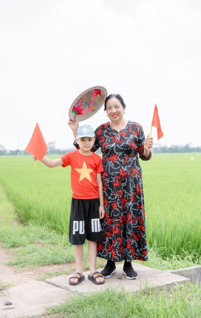 Bà và cháu trên cánh đồng lúa quê nhà