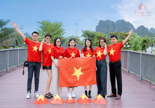 Gia đình bên cầu gỗ Hạ Long, cờ đỏ trên tay