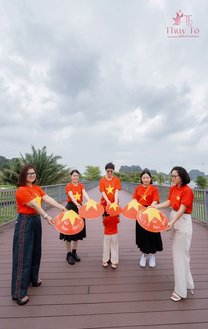 Gia đình bên cầu gỗ Hạ Long, cờ đỏ trên tay